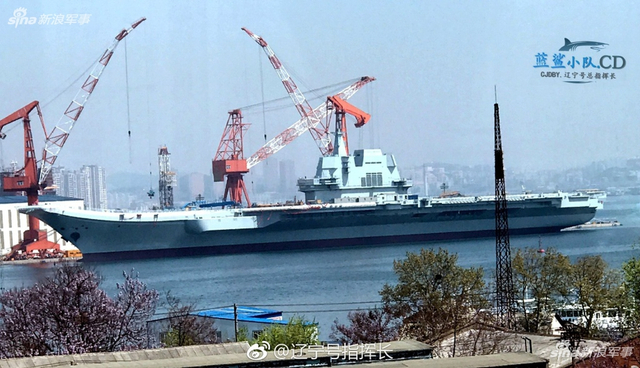 工人检查舰艏的情况:国产航母下水后继续施工