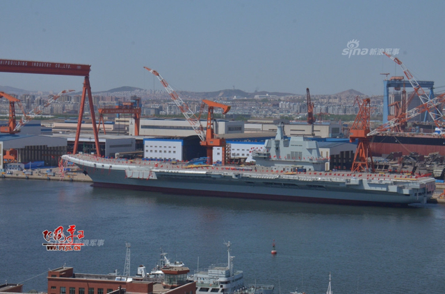 工人检查舰艏的情况:国产航母下水后继续施工