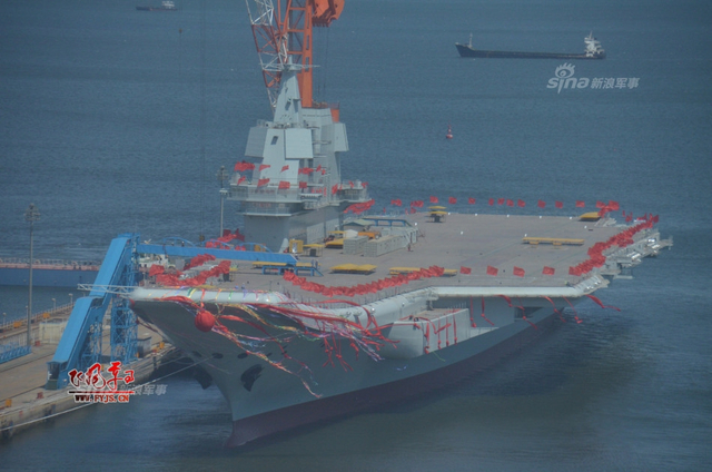 工人检查舰艏的情况:国产航母下水后继续施工