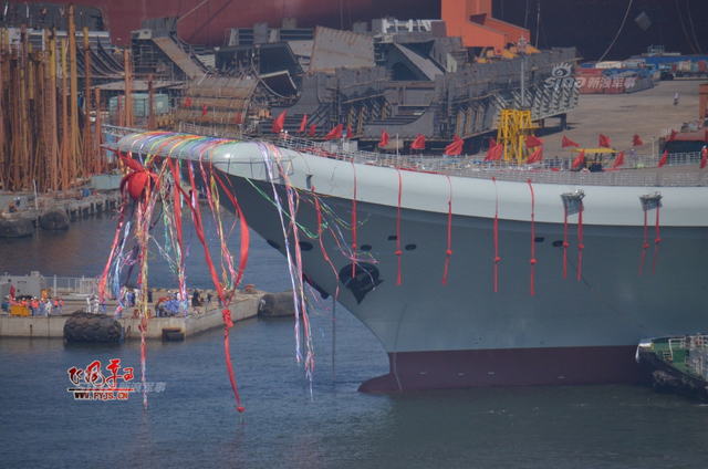 工人检查舰艏的情况:国产航母下水后继续施工