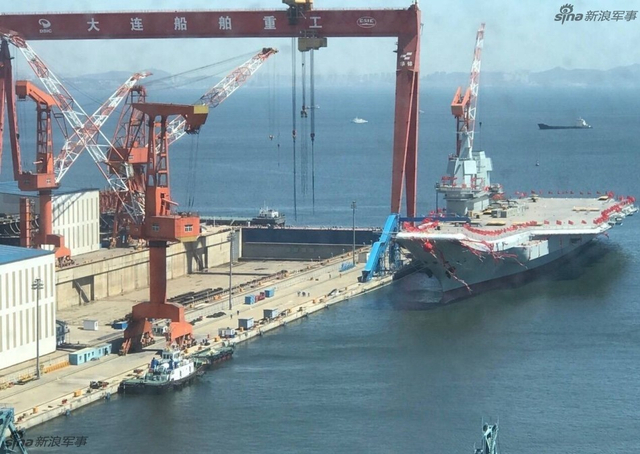 工人检查舰艏的情况:国产航母下水后继续施工