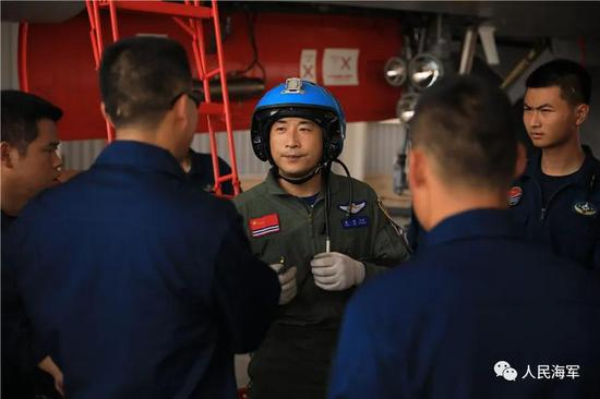 ▲训练结束后，袁伟走下战机与机务人员交流