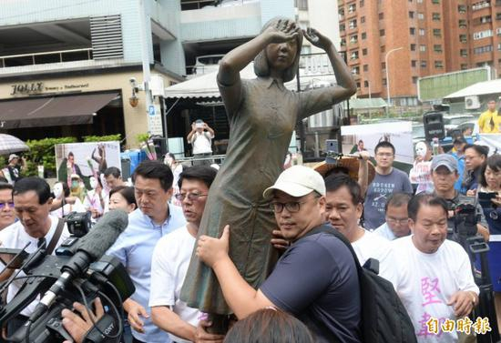 现场民众扛起铜像往前冲&nbsp; 图源：《自由时报》