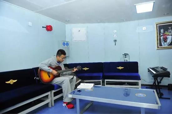  餐厅的一角，海苔妹捕获音乐文艺男一枚，谈起航母上成立了四年的“深蓝乐队”，吉他手王敬文感觉就像回到了校园时光。 