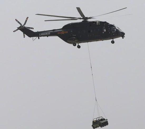 图为吊挂标准型8X8“山猫”全地形车的直-8G直升机。