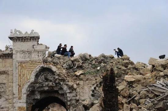 2017年12月17日，在叙利亚阿勒颇老城，几名市民在倭马亚清真寺的废墟上留影。
