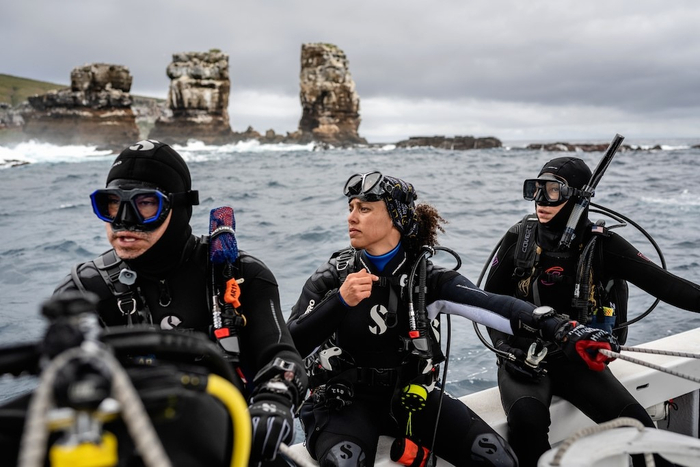查尔斯・达尔文基金会（Charles Darwin Foundation）的莎乐美・布格拉斯（Salome Buglass（中）和同事们在蓝色使命加拉帕戈斯任务期间准备潜水。© Rolex/Franck Gazzola