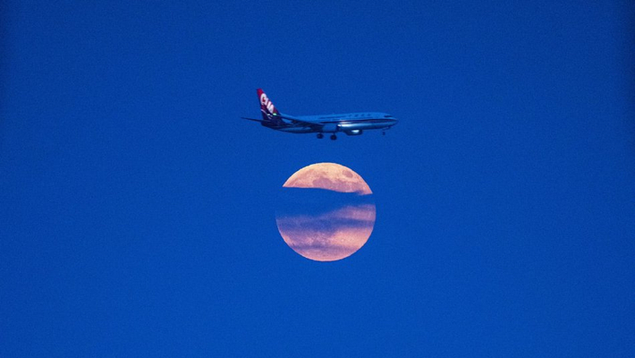 浙江温州夜空现“飞机穿月”景观