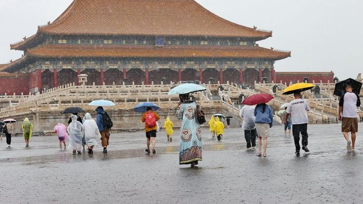 北京暴雨来袭 游客冒雨游览故宫兴致不减