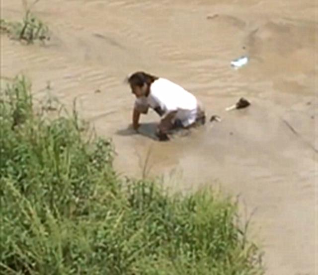 女子跳河寻死 因水太浅躺在淤泥上 新浪图片