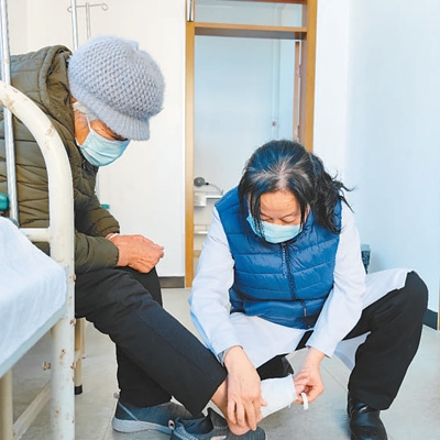 北京市怀柔区杨宋镇太平庄村村医马爱民（右）为席奶奶换药。本报记者 杨彦帆摄