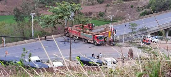  ▲6月8日，昆明与玉溪市边界处，国道上设卡拦截象群，四辆卡车封堵。新京报记者 齐超 摄