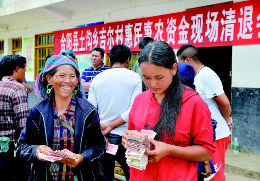 2018年10月28日，四川省凉山州金阳县土沟乡吉尔村村民石一木尔尾（左一）领到清退的彝家新寨建设补助。 受访者供图