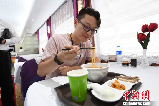 图为旅客拍摄列车上的牛肉面留念。　杨艳敏 摄