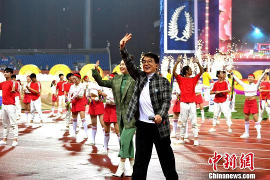  成龙和谭维维共同唱起第十八届世警会主题曲《欢乐与荣耀》。　安源 摄