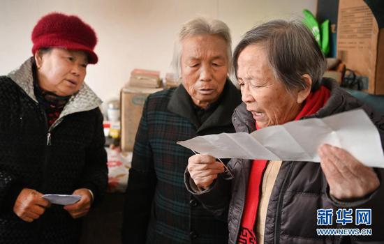 周末，路生梅（右）到黄河对岸的山西省临县克虎镇高家沟村看望50多年的病友马平则（中），村民闻讯向她咨询病情（1月17日摄）。新华社记者 陶明 摄