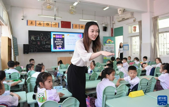深圳市福田区南园小学教师、香港理工大学对外汉语教育专业硕士毕业的香港青年黄晓蕾在英语课上与孩子们互动（9月1日摄）。新华社记者 毛思倩 摄