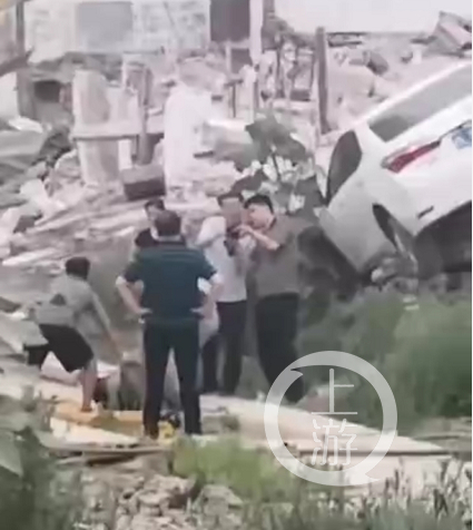 ▲王峥驾驶的白色轿车停在废墟上，胡华东倒在一旁。知情人士供图