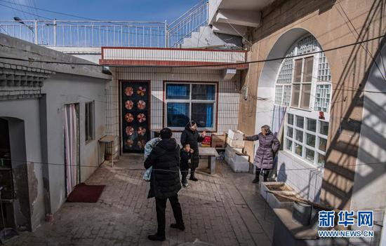 路生梅（右一）在佳县家中义诊，与患儿及家长告别（1月16日摄）。新华社记者 陶明 摄