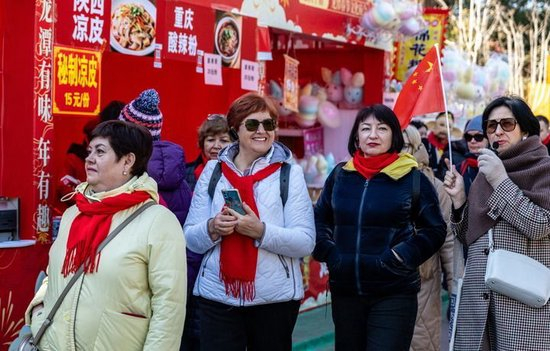 2026年2月17日，外国游客在北京龙潭湖公园逛春节文化庙会。新华社发（赵琦 摄）