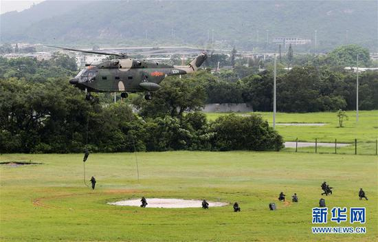 6月29日，解放军驻港部队特战队员从直升机索降。 新华社发（易定 摄）