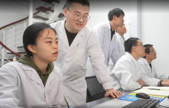 △中国科学院近代物理研究所新核素团队科研人员在观察和记录设备状态。