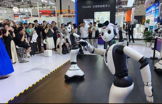 2024年7月5日，在上海举行的2024世界人工智能大会上，一家人工智能公司推出的“具身智能本体”跳舞机器人，吸引观众前来参观。新华社记者 黄晓勇 摄