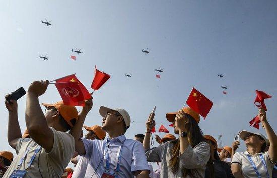 2025年9月3日,纪念中国人民抗日战争暨世界反法西斯战争胜利80周年大会在北京隆重举行。这是观众拍摄空中护旗梯队通过天安门广场。新华社记者 李安 摄