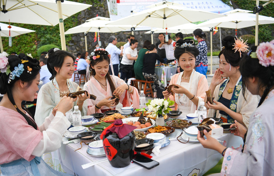 游客在第二十三届中国安康汉江龙舟节的“汉江排子席”上品尝美食（6月22日摄）。新华社发（邹竞一摄）