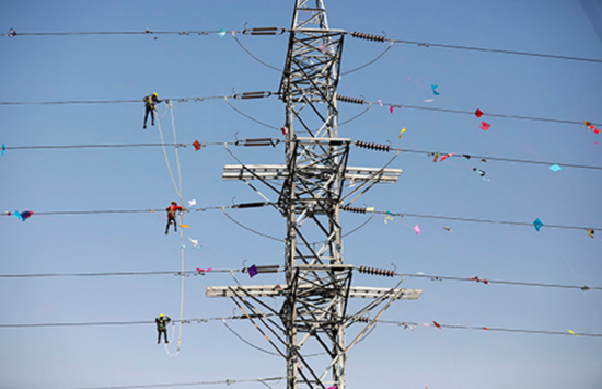 2020年1月16日，印度艾哈迈达巴德，电力公司工作人员清理缠绕在电线上的风筝线。