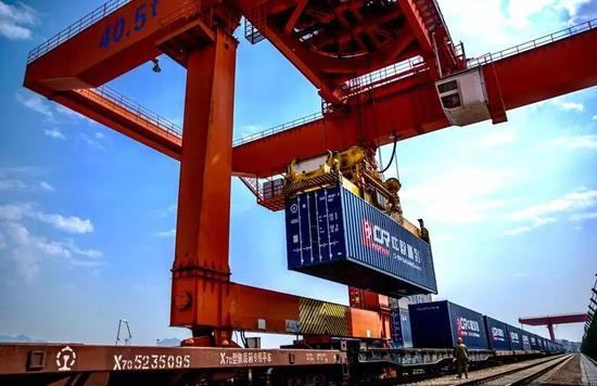 　　▲资料图片：2017年4月15日，浙江义乌西站铁路口岸，工作人员正在向中欧班列（义乌-马德里）吊装集装箱。