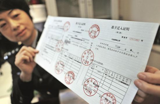 2017年3月，陕西省西安市碑林分局民警展示已经办理完成的户口准予迁入证明。图/视觉中国