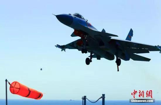 中国海军辽宁舰航母编队连续开展远海实兵对抗演练。图为歼-15战斗机放下尾钩，准备着舰。中新社记者&nbsp;张雷&nbsp;摄