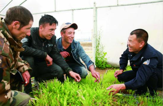 ▲ 新疆红其拉甫边检站民警孙超向塔吉克族牧民传授种植技术。