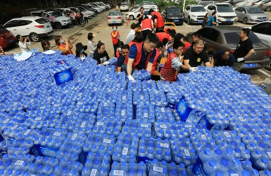 2021年7月24日，郑州市金水区河南宾馆，志愿者在搬运救灾物资。