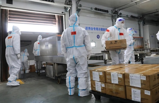 10月20日，第五届进博会首单冷链食品展品抵沪入仓，工作人员在总仓内搬运完成卸车消毒的冷链食品展品。图源：新华社