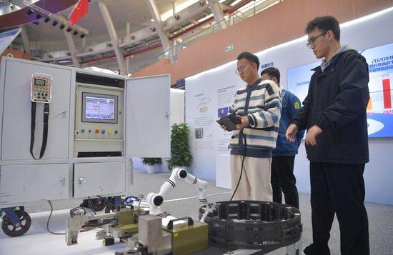 2023年，京南地区高校科技成果推介会在北京建筑大学大兴校区举行。图为高校师生在展示管道全位置焊接机器人系统成果。