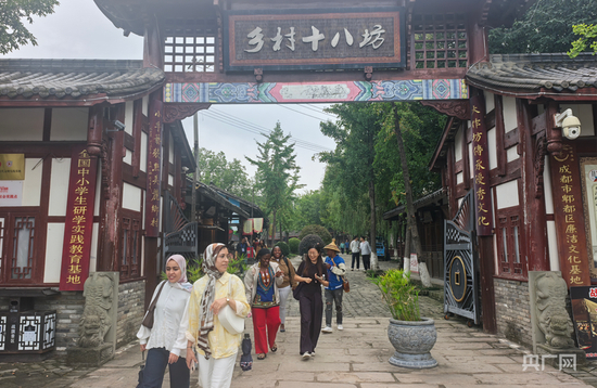  来自各地的游客在战旗村乡村十八坊游览观光（央广网记者 昌思荣 摄）
