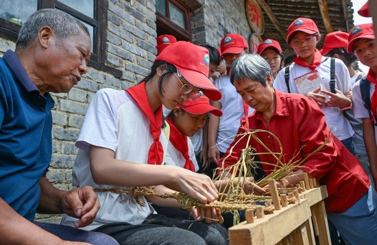 9月3日，重庆市綦江区安稳学校的学生参加“綦迹少年·重走长征路”活动，在村民指导下体验编草鞋。新华社记者陈诚 摄