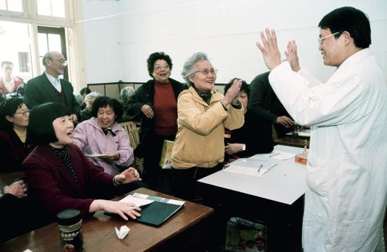  2003年5月，上海南京西路街道愚谷村居委会，卢洪洲等上海华山医院传染科的医生进入社区，向市民宣讲如何防控SARS疫情传染。摄影/雍和