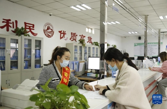 河北省邢台市襄都区宴家屯镇综合服务中心工作人员协助办事群众填写相关表格（2022年3月30日摄）。新华社发（张驰 摄）