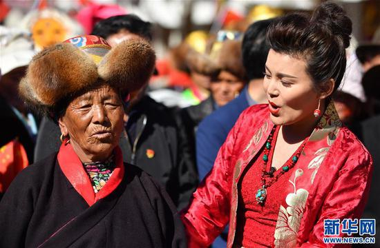 克松社区村民央金（左）和歌手合唱《我和我的祖国》（3月20日摄）。新华社记者 觉果 摄