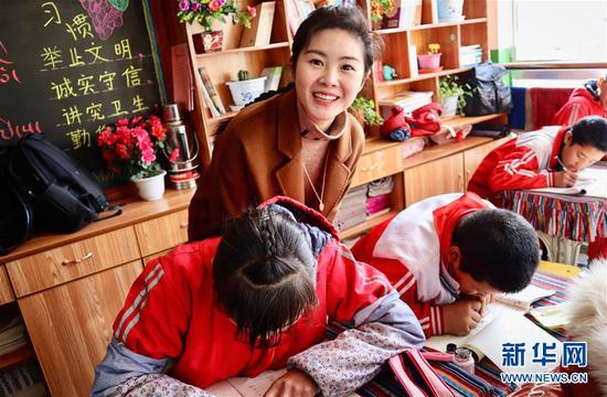  在西藏拉萨的一所小学，参加大学生志愿服务西部计划的上海交通大学博士生梁晴雪在帮学生们辅导功课（2019年3月23日摄）。 新华社发