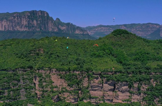 滑翔伞爱好者在河南省林州市太行山区飞行（2023年6月8日摄，无人机照片）。新华社记者 郝源 摄