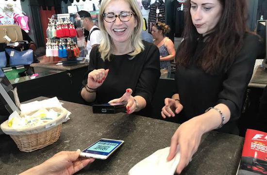 △中国游客正在摩纳哥使用支付宝购物。