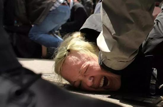 　　（图：美国“占领华尔街”示威行动中，警方则施放催泪弹和闪光弹驱赶人群，逮捕了大约300名示威者。）