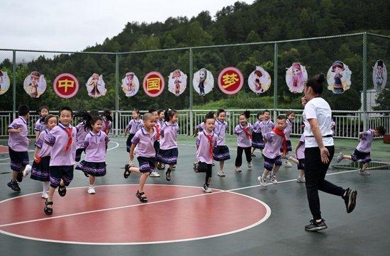  在广西桂林市龙胜各族自治县龙胜镇第二小学，一名老师在指导学生们练习多耶舞蹈动作（2024年6月26日摄）。新华社记者 李尕 摄