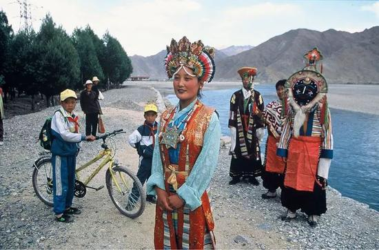 △ 1999年，拉萨，藏族过年时盛装的青年男女，他们鲜艳的服装上搭配有红玛瑙和其他坠饰珠宝。