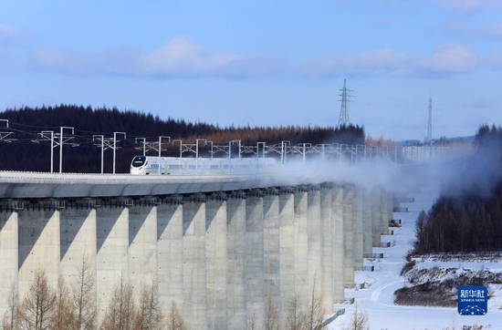 试运行期间，高铁列车行驶在沈佳高铁白敦段上（2021年12月3日摄，无人机照片）。2021年12月24日，沈阳至佳木斯高铁长白山至敦化段正式开通运营，长白山风景区接入全国高铁网，长春至长白山最快2小时18分可达。沈佳高铁白敦段位于吉林省延边朝鲜族自治州境内，设计时速250公里，由于其穿越原始森林，被誉为“森林高铁”。新华社发（刘慎库 摄）