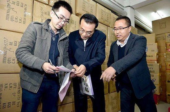 李克强在批发商童志达（右一）的公司考察。